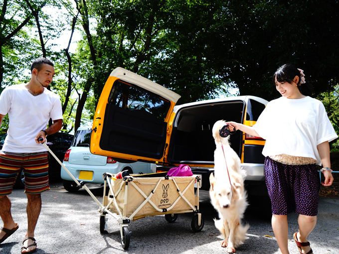 ▲アウトドア好きという上杉さん夫妻と、車から勢いよく降りる愛犬のあんず